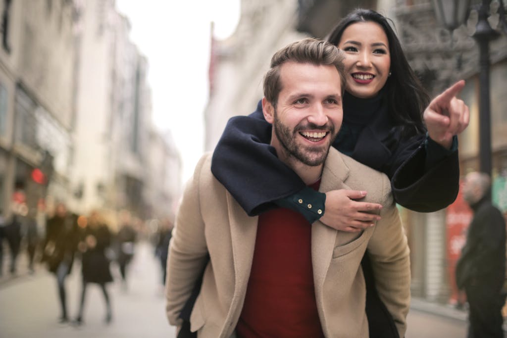 Cheerful couple having fun and laughing while exploring the city streets.